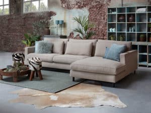 Hoekbank Gigi met een longchair in een beige stof met blauwkleurige sierkussens