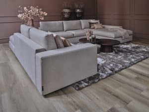 Ruime hoekbank in een beige stof. Met sfeervolle woonaccessoires.
