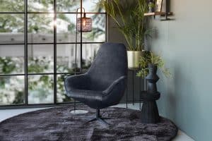 Draaifauteuil in antraciet met zwarte sterpoot, met rond vloerkleed.
