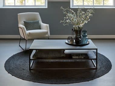 Zwarte Heavy Metal Coffeetable 120cm, met boucle fauteuil en rond vloerkleed.