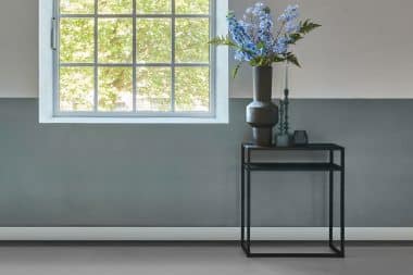 Zwarte sidetable Heavy Metal 70cm breed, met vaas met zijdebloemen en meer decoratie.