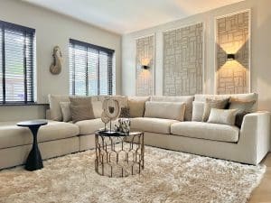 Binnenkijken chique interieur: Beige bank met kussens en gouden details