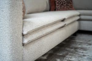 Hoekbank Nadine met dubbele rug- en zitkussens in een beige stof, in een sfeervol interieur.
