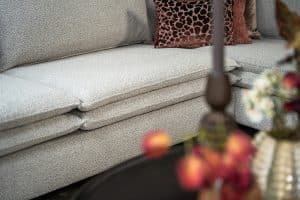 Hoekbank Nadine met dubbele rug- en zitkussens in een beige stof, in een sfeervol interieur.