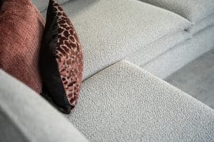 Hoekbank Nadine met dubbele rug- en zitkussens in een beige stof, in een sfeervol interieur.