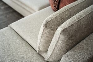 Hoekbank Nadine met dubbele rug- en zitkussens in een beige stof, in een sfeervol interieur.