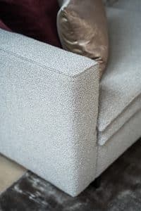 Hoekbank Nadine met dubbele rug- en zitkussens in een beige stof, in een sfeervol interieur.