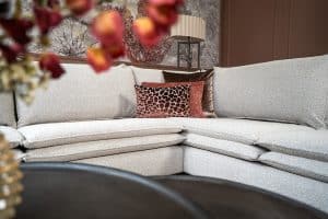 Hoekbank Nadine met dubbele rug- en zitkussens in een beige stof, in een sfeervol interieur.