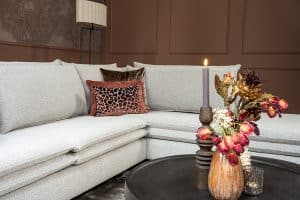 Hoekbank Nadine met dubbele rug- en zitkussens in een beige stof, in een sfeervol interieur.