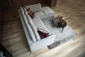 Hoekbank Nadine met dubbele rug- en zitkussens in een beige stof, in een sfeervol interieur.
