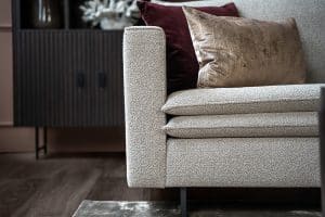 Hoekbank Nadine met dubbele rug- en zitkussens in een beige stof, in een sfeervol interieur.