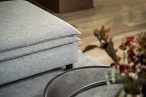 Hoekbank Nadine met dubbele rug- en zitkussens in een beige stof, in een sfeervol interieur.