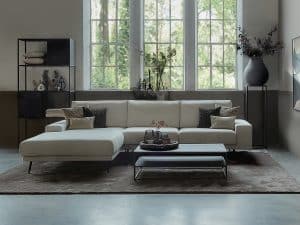 Hoekbank Rosalie in een beige stof. Gestyled met zwart metalen meubelen en een groot vloerkleed.