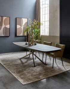 Deens ovale eettafel in een donkere bruine kleur. Massief hout. Met mos groene eetkamerstoelen met armleuning. Sfeervolle afstyling.