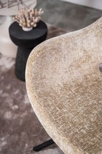 Beige eetkamerstoel met een zwart onderstel en een kuipzitting
