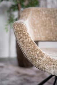 Beige eetkamerstoel met een zwart onderstel en een kuipzitting