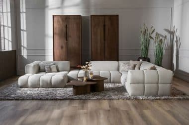 Beige hoekbank met blokken. In een modern interieur en rechthoekig vloerkleed.