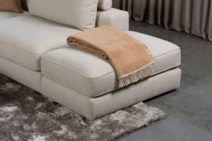 Beige bank met verschillende elementen en een sfeervolle rood / roze interieurstyling.