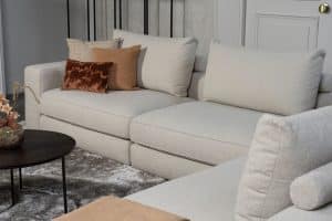 Beige bank met verschillende elementen en een sfeervolle rood / roze interieurstyling.