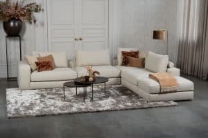 Beige bank met verschillende elementen en een sfeervolle rood / roze interieurstyling.