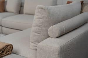 Beige bank met verschillende elementen en een sfeervolle rood / roze interieurstyling.