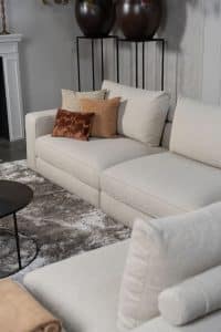 Beige bank met verschillende elementen en een sfeervolle rood / roze interieurstyling.