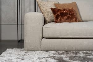 Beige bank met verschillende elementen en een sfeervolle rood / roze interieurstyling.