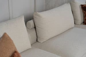Beige bank met verschillende elementen en een sfeervolle rood / roze interieurstyling.