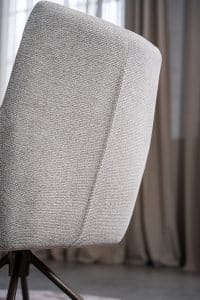 Detail van lichte natural eetkamerstoel met armleuning.