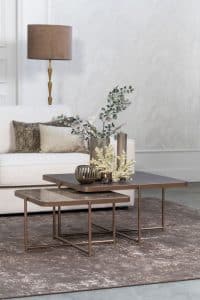Lichte beige hoekbank met bruine woonaccessoires.