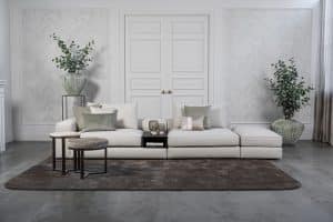 Lichte modulaire elementenbank Eva met innerbench en zachte kussens, gestyled met accessoires in een modern interieur.