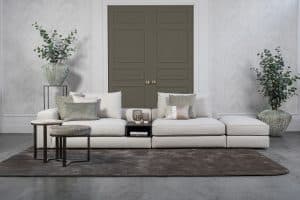 Lichte modulaire elementenbank Eva met innerbench en zachte kussens, gestyled met accessoires in een modern interieur.