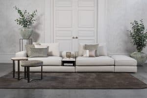 Lichte modulaire elementenbank Eva met innerbench en zachte kussens, gestyled met accessoires in een modern interieur.