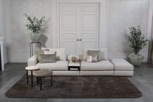 Lichte modulaire elementenbank Eva met innerbench en zachte kussens, gestyled met accessoires in een modern interieur.