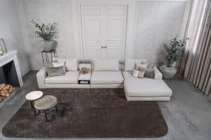 Lichte modulaire elementenbank Eva met innerbench en zachte kussens, gestyled met accessoires in een modern interieur.