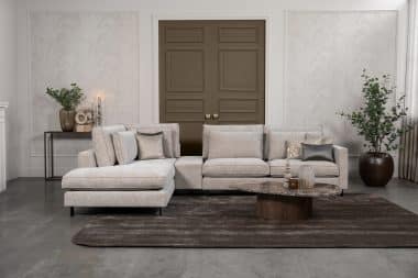 Hoekbank Gigi in een neutrale beige kleur, gestyled met accessoires in warme aardetinten.