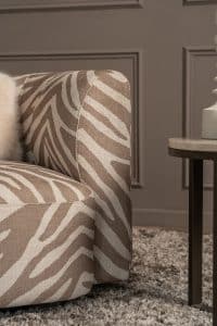De Emanuelle Twist fauteuil is een stijlvolle draaifauteuil met afgeronde lijnen, beschikbaar in een uitgebreide stoffencollectie en verschillende kleuren.