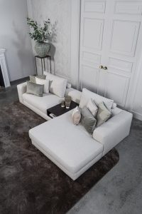 Lichte modulaire elementenbank Eva met innerbench en zachte kussens, gestyled met accessoires in een modern interieur.