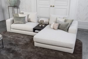 Lichte modulaire elementenbank Eva met innerbench en zachte kussens, gestyled met accessoires in een modern interieur.