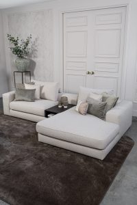 Lichte modulaire elementenbank Eva met innerbench en zachte kussens, gestyled met accessoires in een modern interieur.