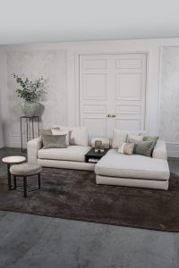 Lichte modulaire elementenbank Eva met innerbench en zachte kussens, gestyled met accessoires in een modern interieur.