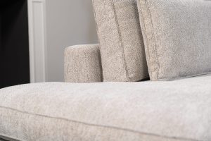 Hoekbank Gigi in een neutrale beige kleur, gestyled met accessoires in warme aardetinten.