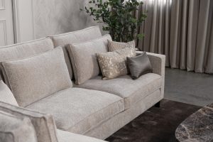 Hoekbank Gigi in een neutrale beige kleur, gestyled met accessoires in warme aardetinten.