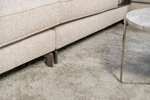 Hoekbank Mila in stof Gautier 7 met slanke metalen poten, losse kussens en een royale loungezijde in een moderne hoekopstelling.