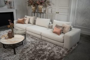 Beige bank met verschillende elementen en een sfeervolle rood / roze interieurstyling.