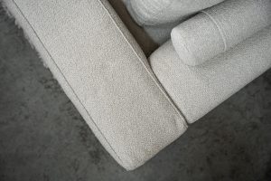 Beige bank met verschillende elementen en een sfeervolle rood / roze interieurstyling.