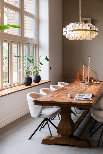 houten eettafel met beige eetkamerstoelen in een rustiek interieur.