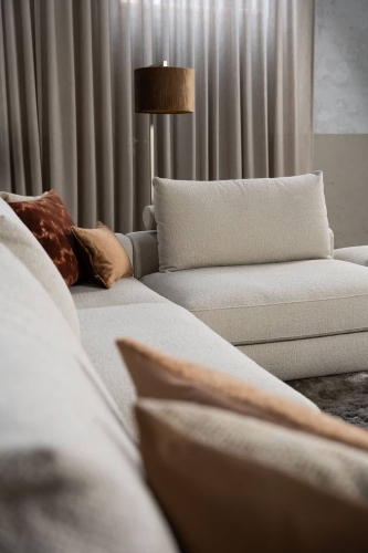 Beige bank met verschillende elementen en een sfeervolle rood / roze interieurstyling.
