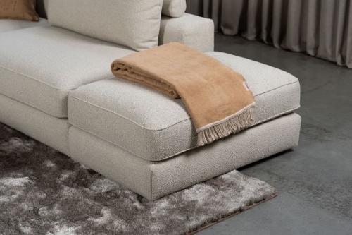 Beige bank met verschillende elementen en een sfeervolle rood / roze interieurstyling.