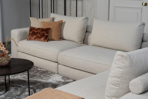 Beige bank met verschillende elementen en een sfeervolle rood / roze interieurstyling.